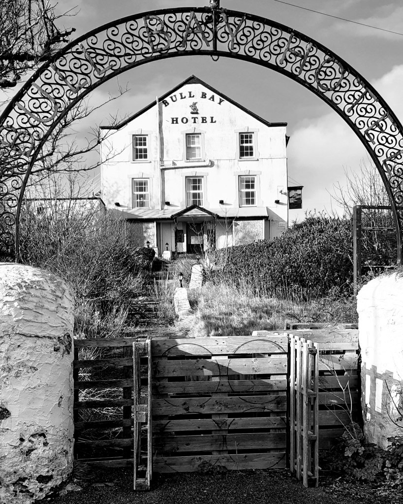 through an iron archway and up some steps is a big white house